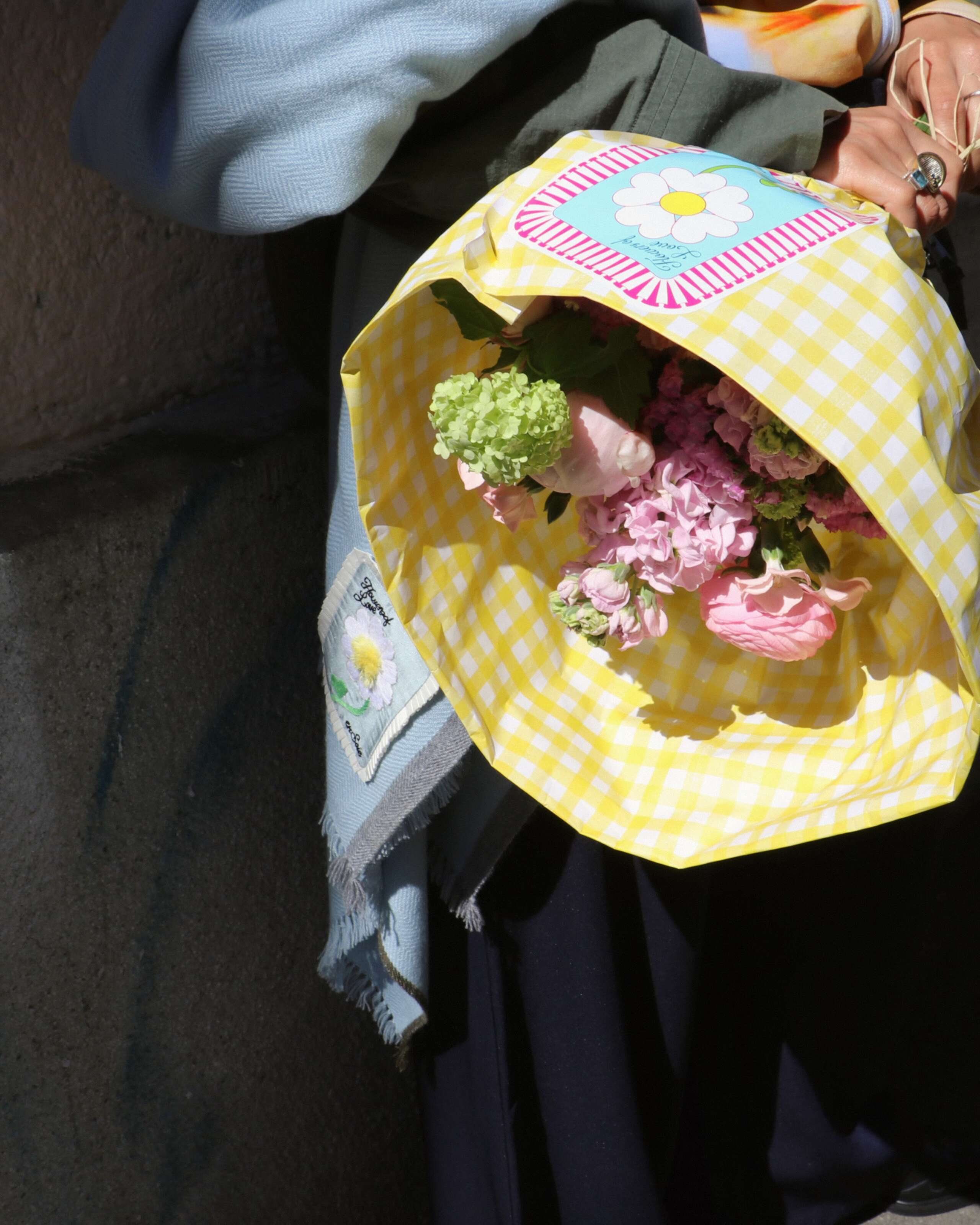 Picture of a women holding a flower bouquet wrapped in a yellow paper