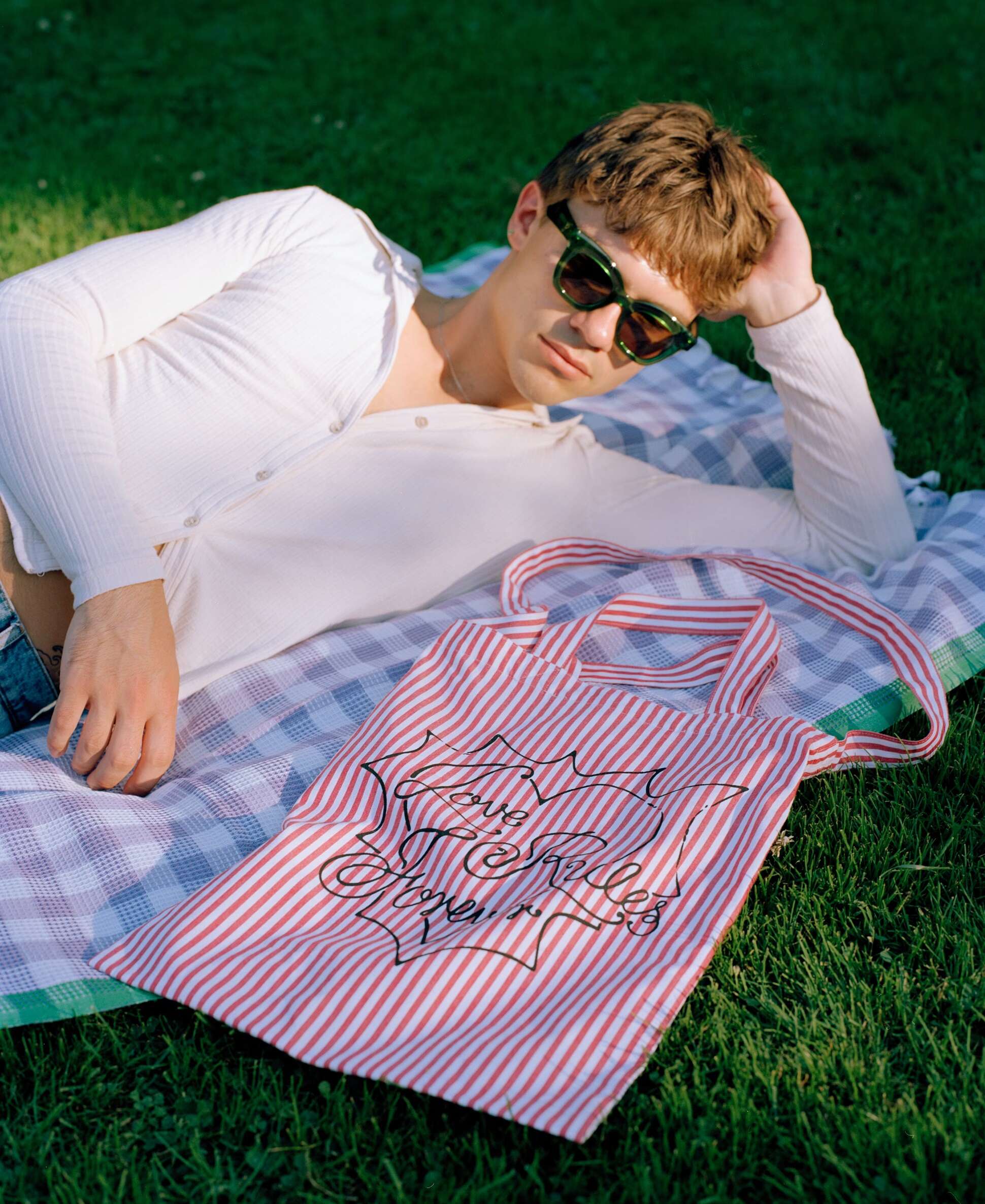 Picture of a young man in a park carrying an enSoie Carry all bag