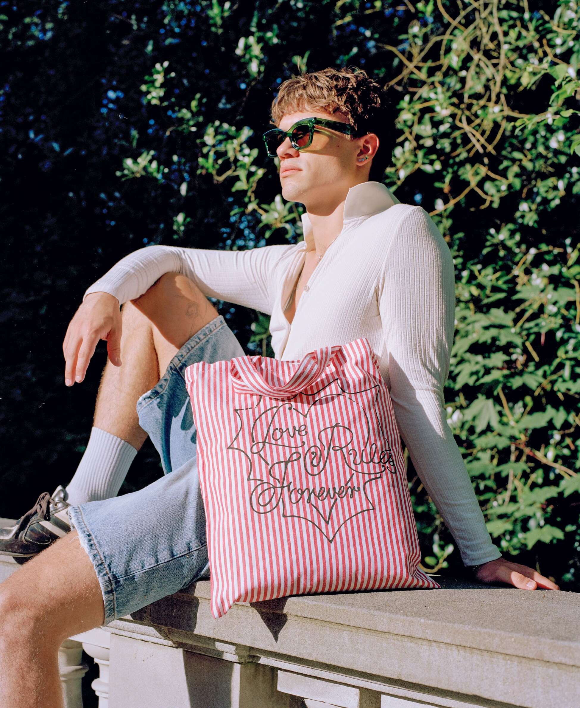 Picture of a young man in a park carrying an enSoie Carry all bag