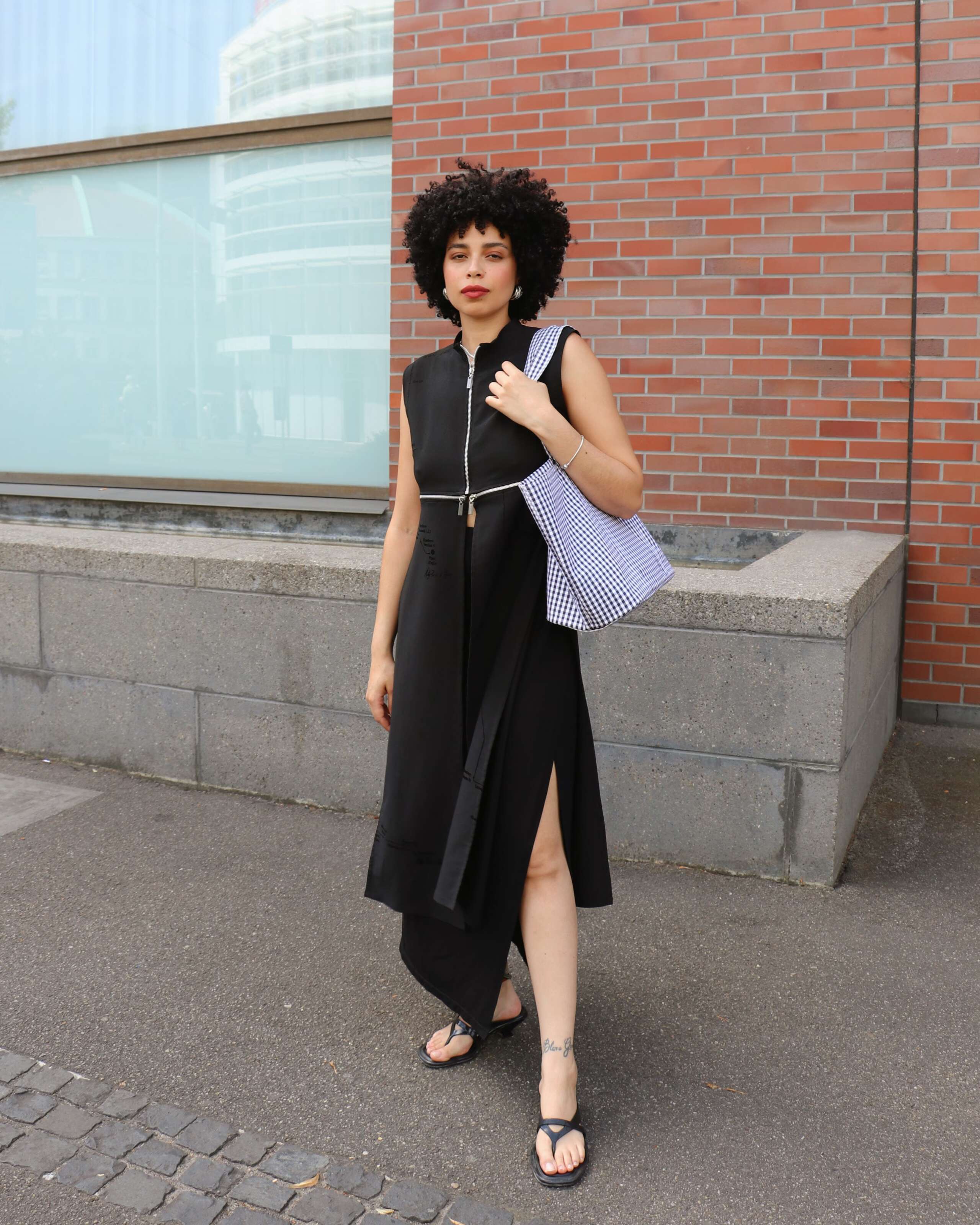Picture of a women standing in front of a brick wall carrying the new Academia bag by enSoie
