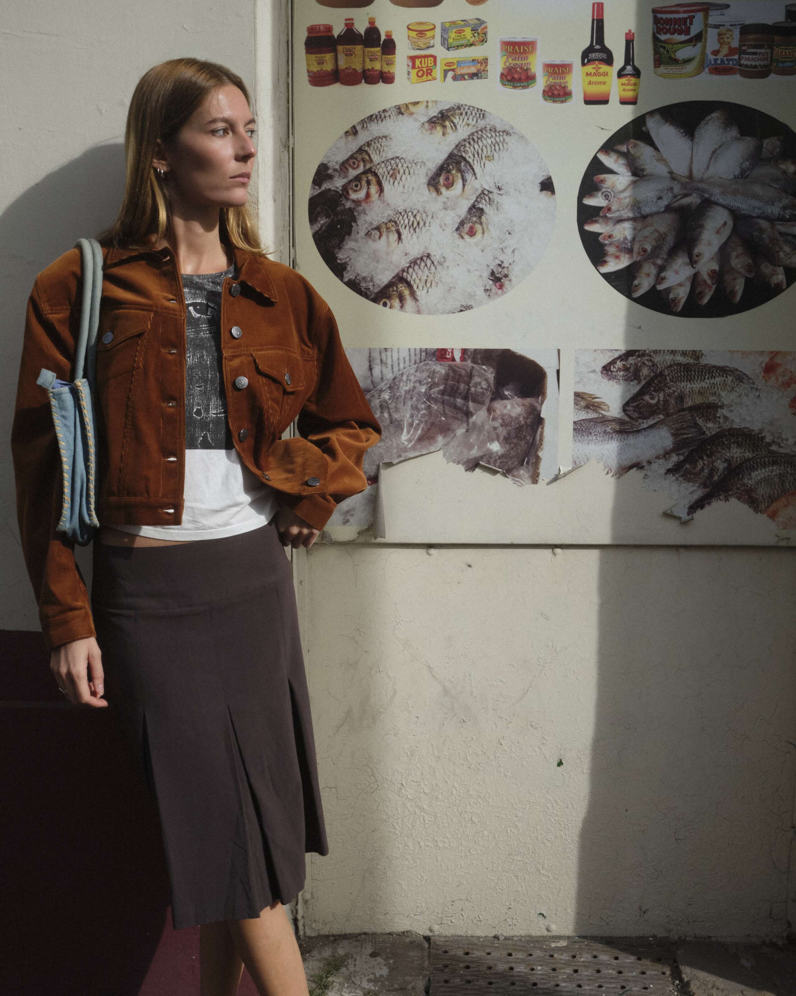 A young women is standing in front of a wall wearing the enSoie Jill jacket