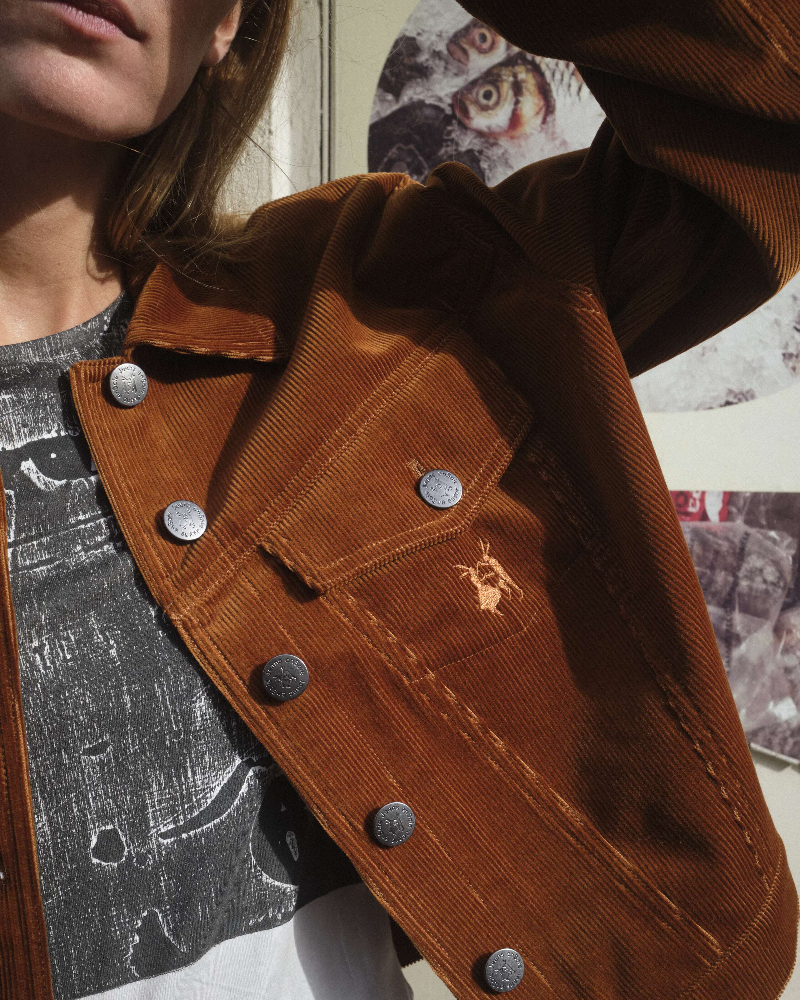 A young women is standing in front of a wall wearing the enSoie Jill jacket