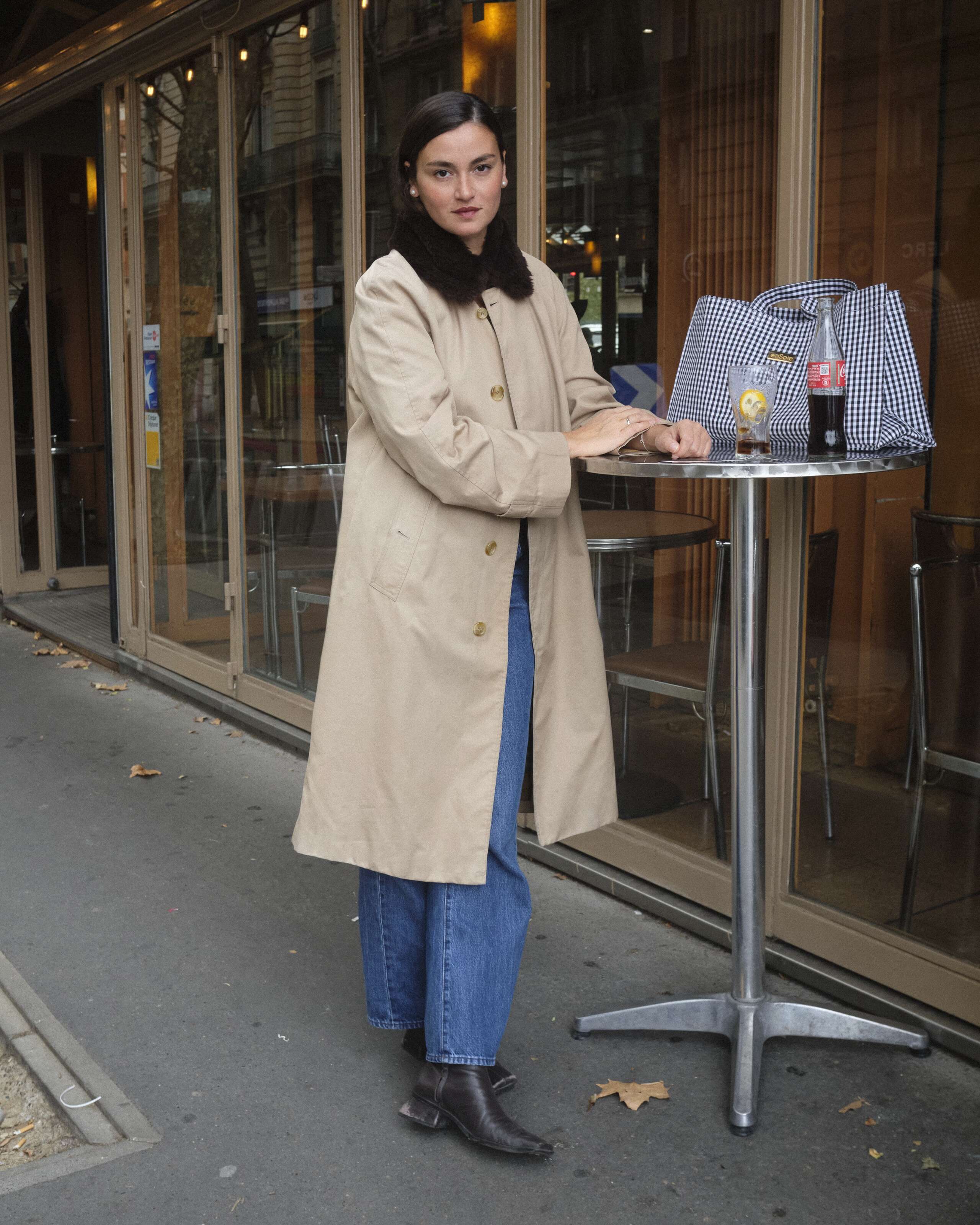 Picture of a young women standing at a bistrot table in Paris